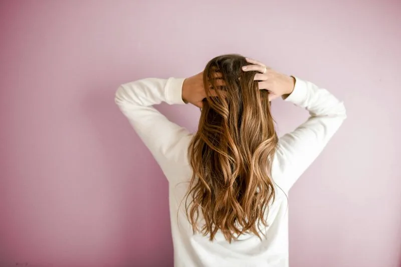 Capelli lunghi mossi con riflessi caramello, vista di spalle